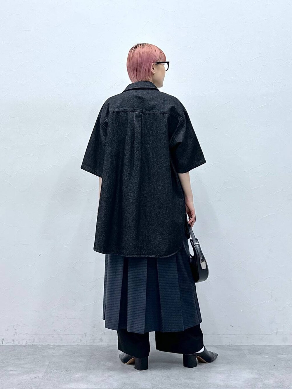 ブラック系のスラックス、グレー系のスカート、ブラック系のシャツ/ブラウスを着用したレディースの春コーディネートの5枚目の写真