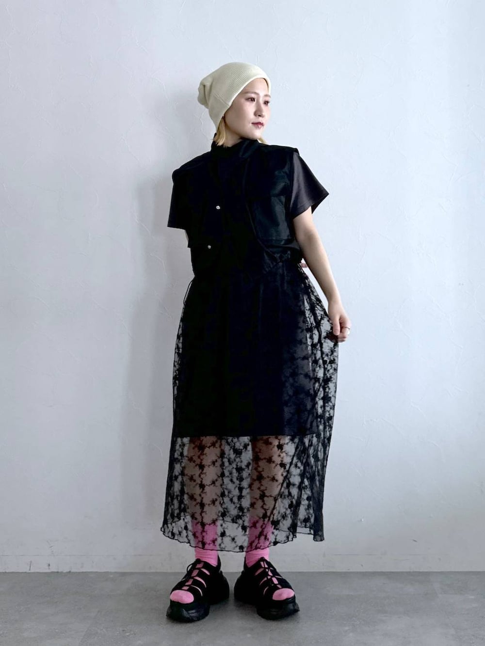 グレー系のワンピース、ブラック系のサンダル、ブラック系のベストを着用したレディースの夏コーディネートの2枚目の写真