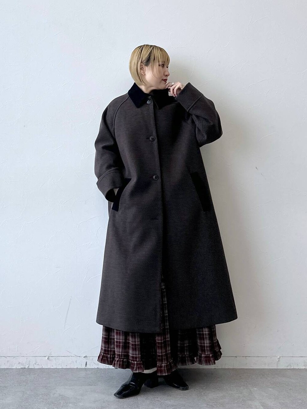 ブラウン系のステンカラーコート、レッド系のスカートを着用したレディースの秋コーディネートの2枚目の写真