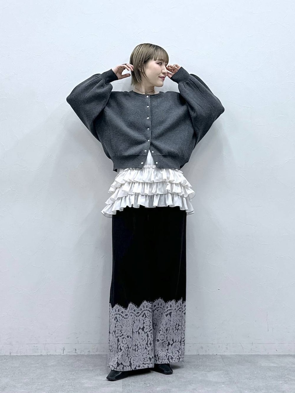 ホワイト系のキャミソール、グレー系のカーディガン/ボレロ、ブラック系のデニムパンツを着用したレディースの冬コーディネートの3枚目の写真