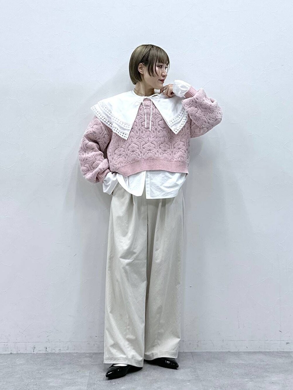 ホワイト系のチノパンツ、ホワイト系のシャツ/ブラウス、ピンク系のニット/セーターを着用したレディースの冬コーディネートの3枚目の写真