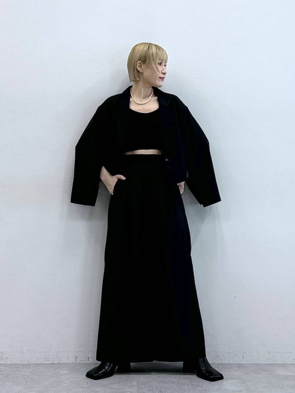 ブラック系のテーラードジャケット、ブラック系のブラジャーを着用したレディースの秋コーディネートの2枚目の写真