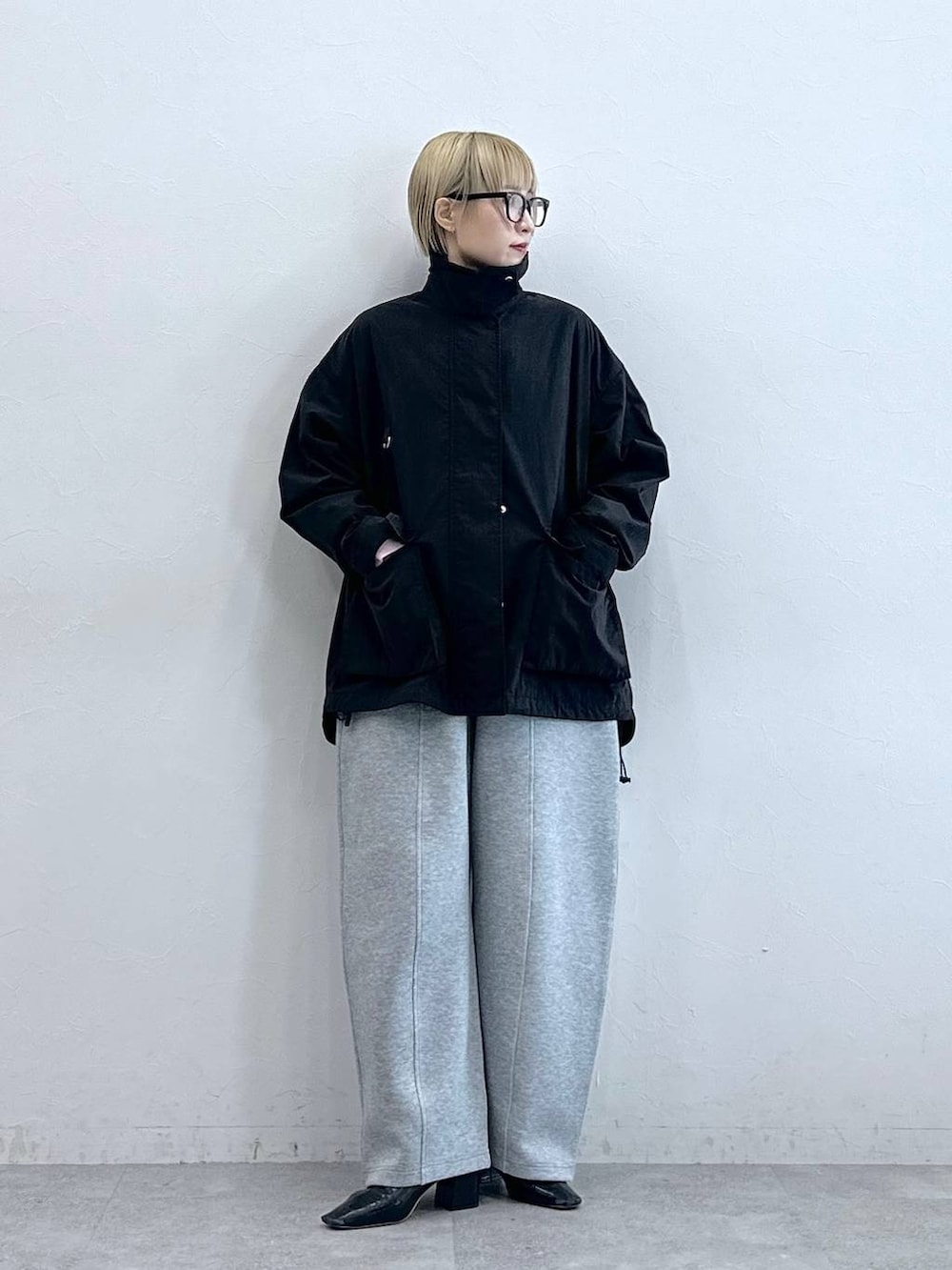 ブラック系のブルゾン、グレー系のスウェットパンツ、グレー系のメガネを着用したレディースの秋コーディネートの3枚目の写真
