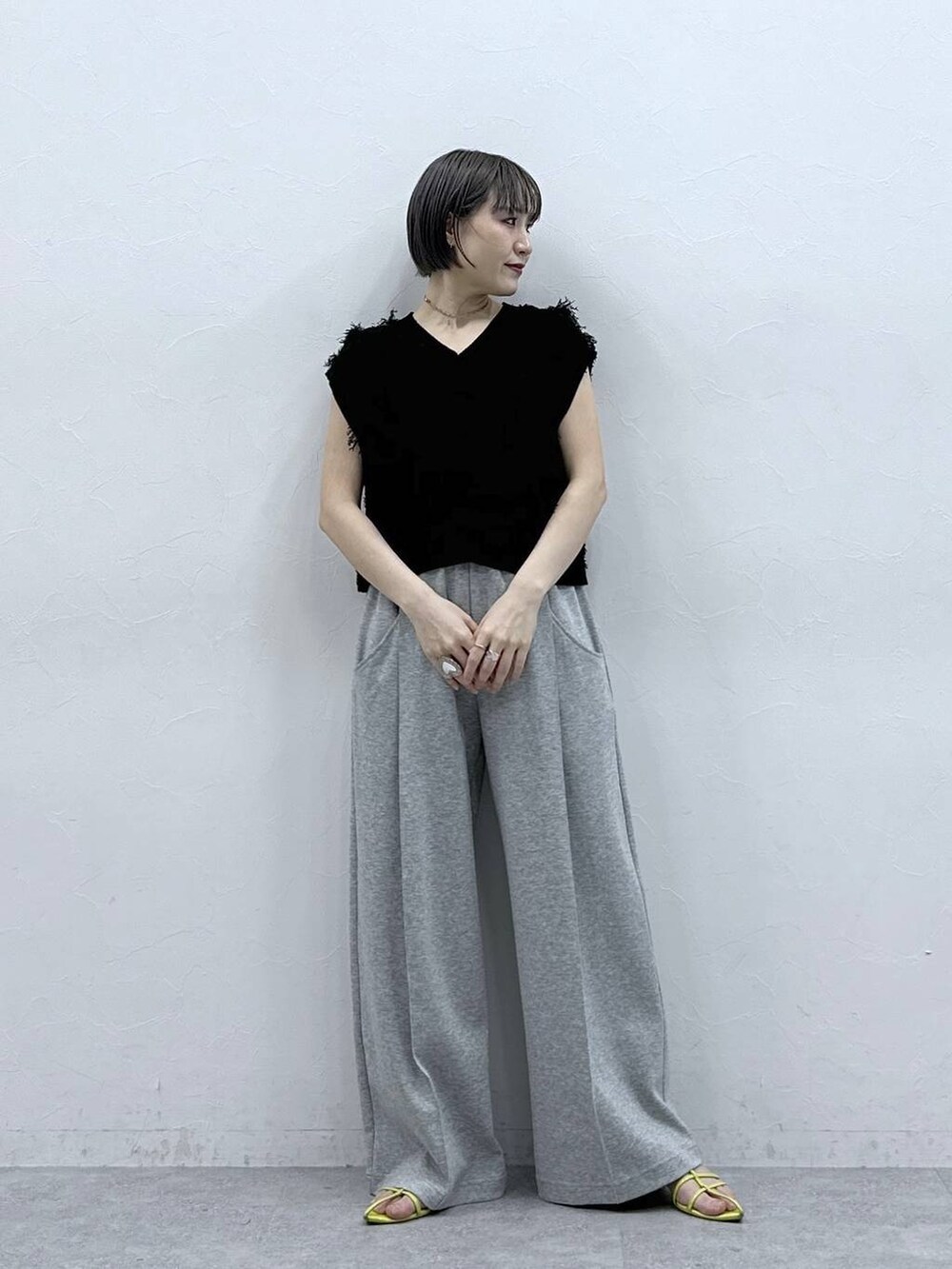 グレー系のスウェットパンツ、ブラック系のベストを着用したレディースの春コーディネートの3枚目の写真