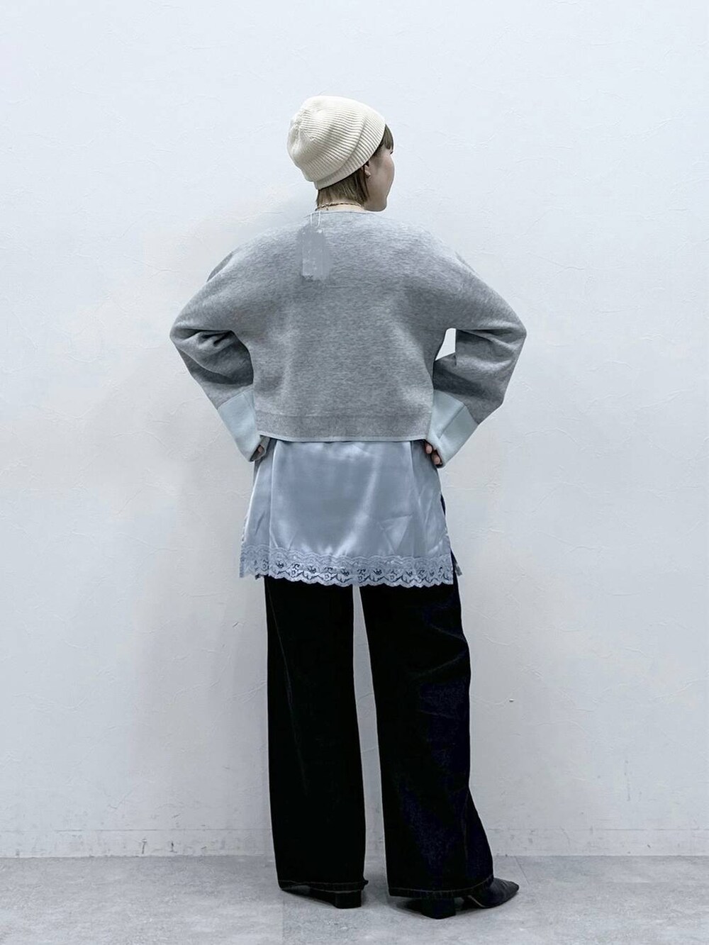 グレー系のカーディガン/ボレロ、ブラック系のデニムパンツ、ブルー系のキャミソールを着用したレディースの冬コーディネートの5枚目の写真