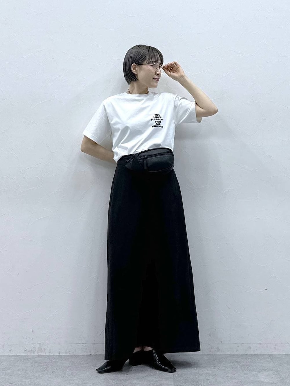 ブラック系のボディバッグ/ウエストポーチ、ブラック系のスカート、ホワイト系のTシャツ/カットソーを着用したレディースの春コーディネートの2枚目の写真