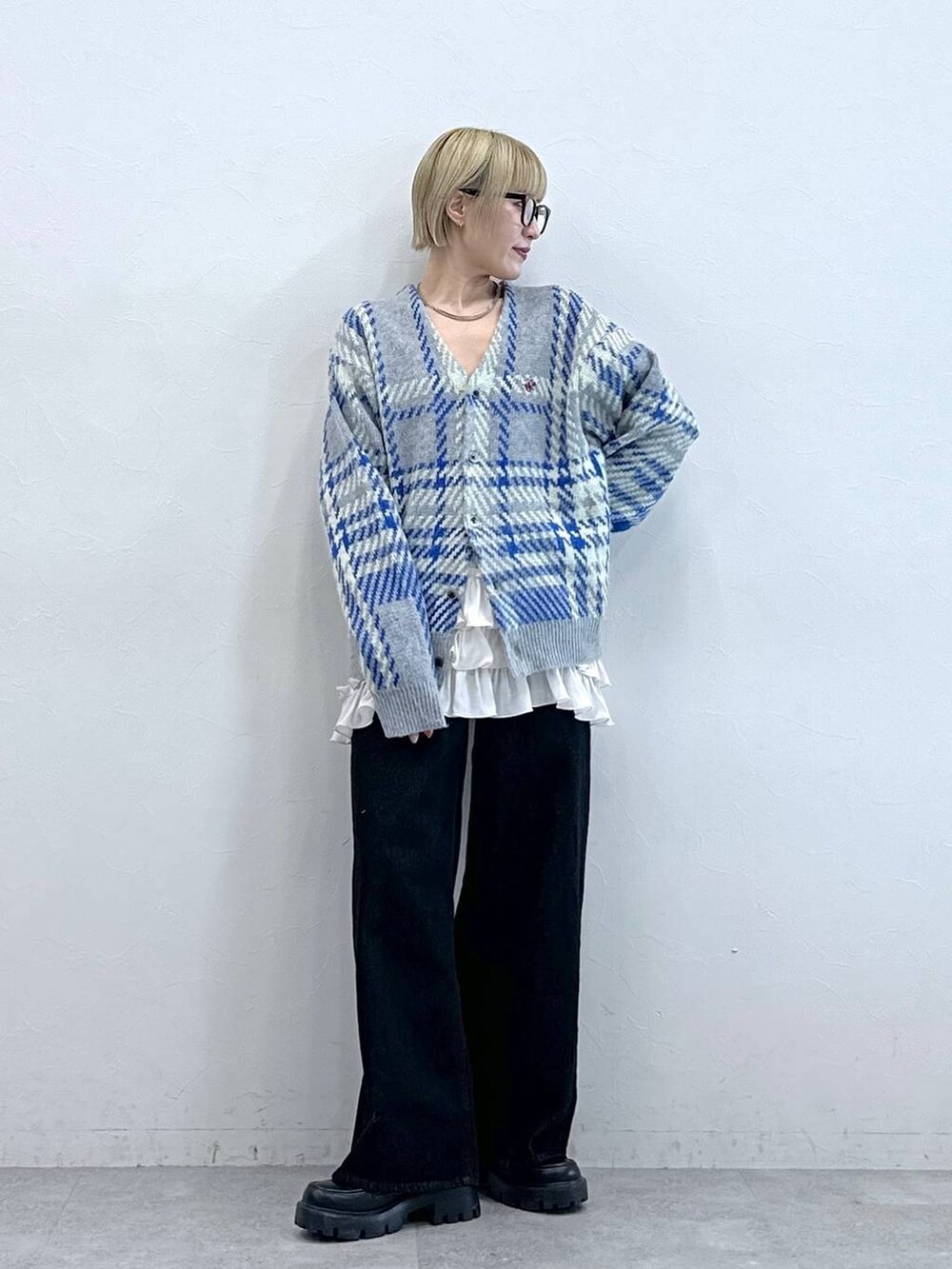 ブラック系のデニムパンツ、ブラック系のローファー、グレー系のニット/セーターを着用したレディースの秋コーディネートの2枚目の写真