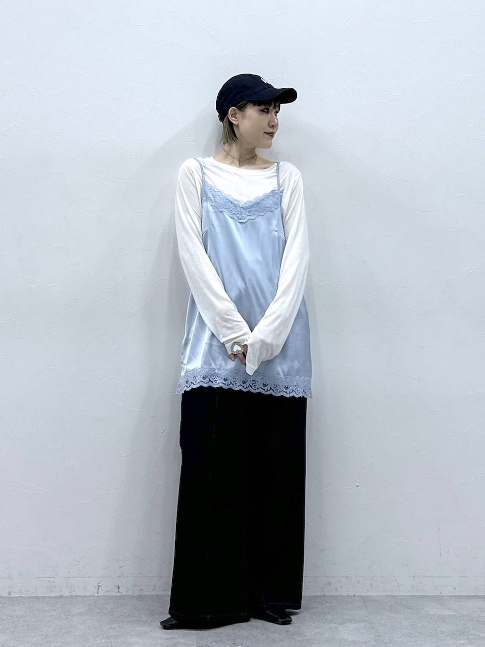 ブラック系のデニムパンツ、ブルー系のキャミソール、ホワイト系のTシャツ/カットソーを着用したレディースの冬コーディネートの2枚目の写真