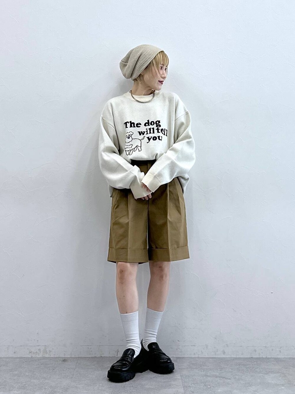 ホワイト系のニット/セーター、ブラック系のローファー、ブラウン系のチノパンツを着用したレディースの秋コーディネートの4枚目の写真