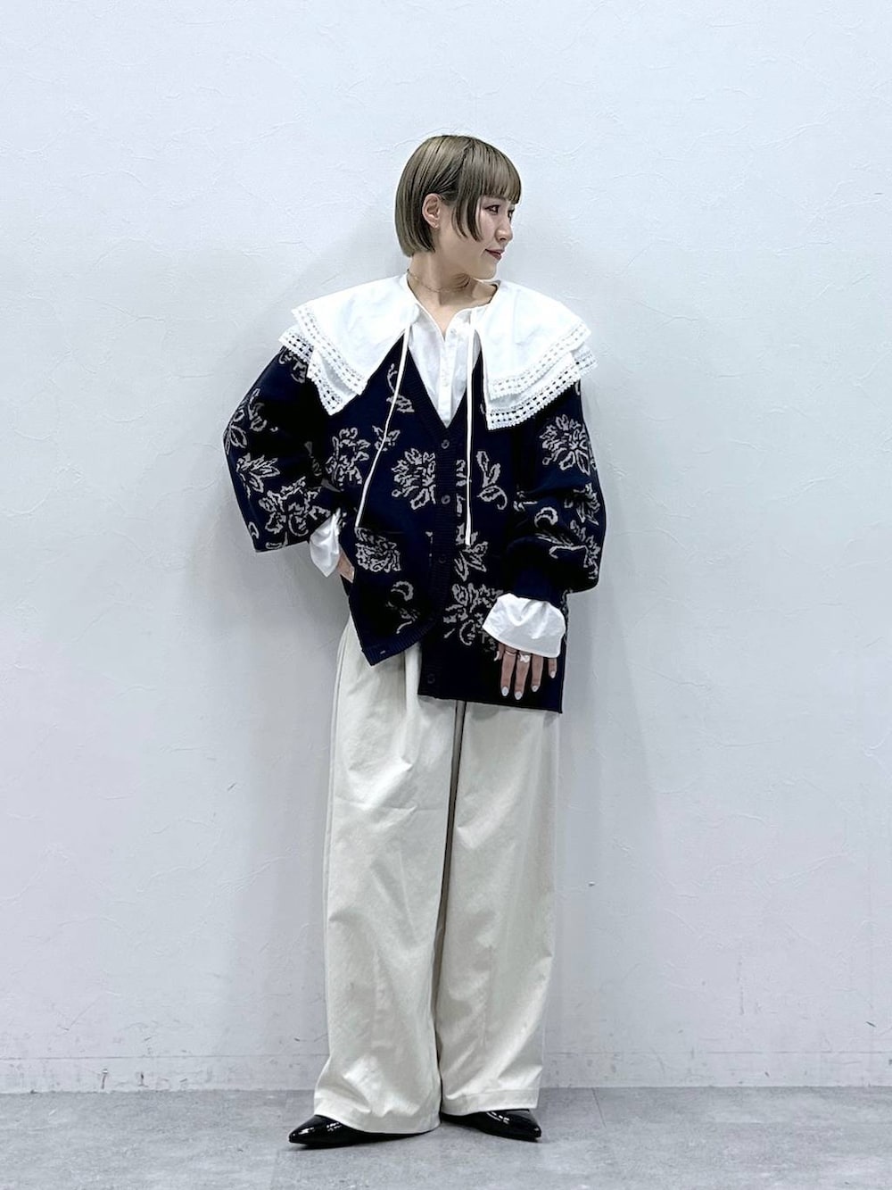 ホワイト系のチノパンツ、ホワイト系のシャツ/ブラウス、ブルー系のニット/セーターを着用したレディースの冬コーディネートの4枚目の写真