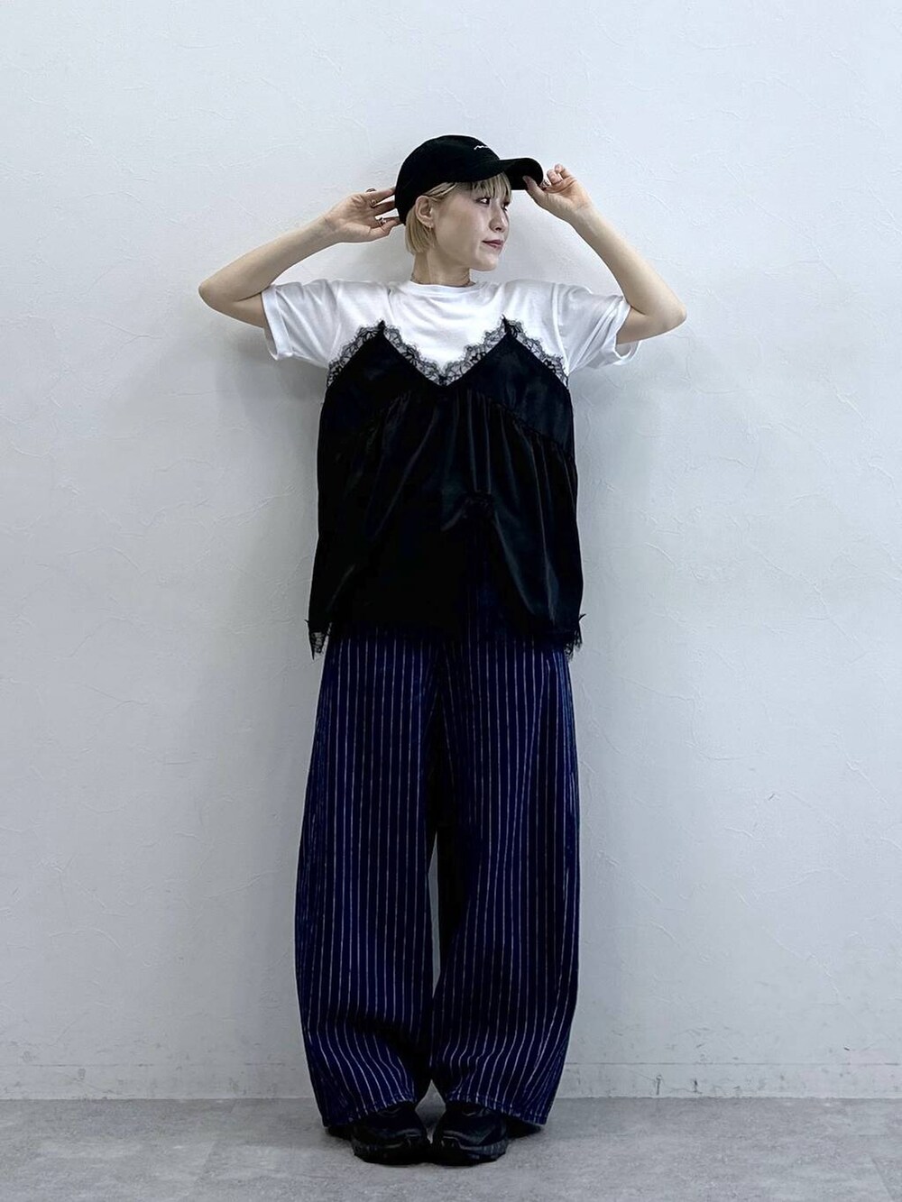 ブラック系のサンダル、ホワイト系のTシャツ/カットソー、ブルー系のデニムパンツを着用したレディースの春コーディネートの2枚目の写真