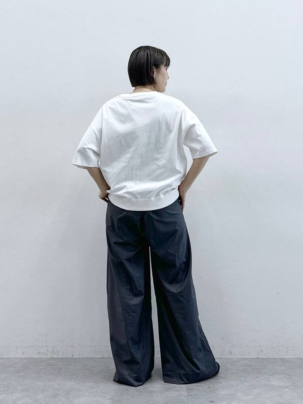 ホワイト系のTシャツ/カットソー、グレー系のスラックスを着用したレディースの春コーディネートの8枚目の写真