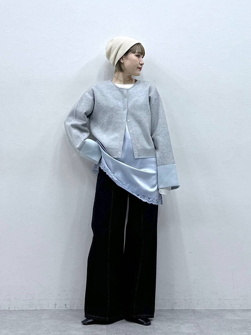 グレー系のカーディガン/ボレロ、ブラック系のデニムパンツ、ブルー系のキャミソールを着用したレディースの冬コーディネートの3枚目の写真