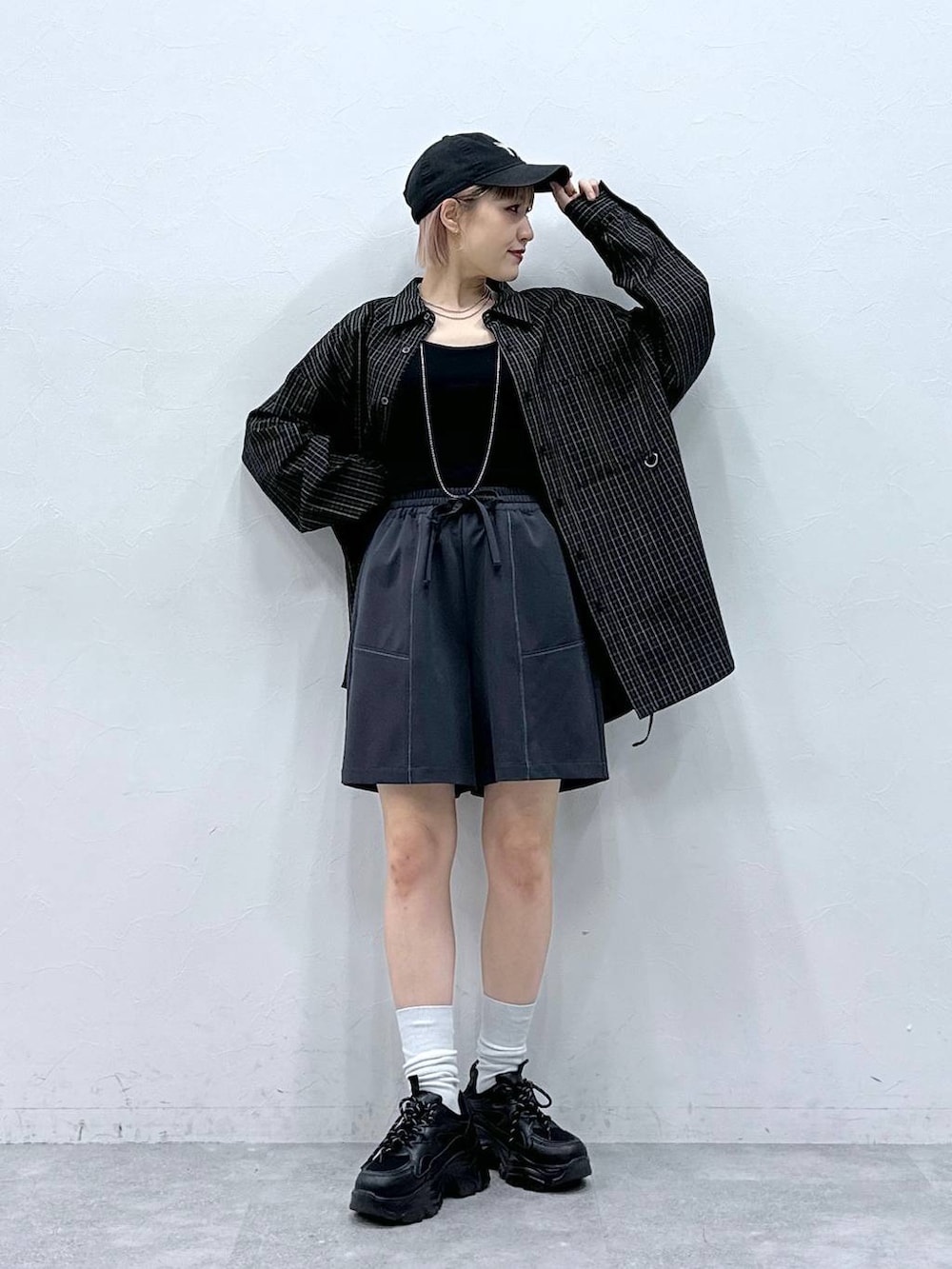 ブラック系のスニーカー、ブルー系のスラックス、ブラック系のシャツ/ブラウスを着用したレディースの春コーディネートの3枚目の写真