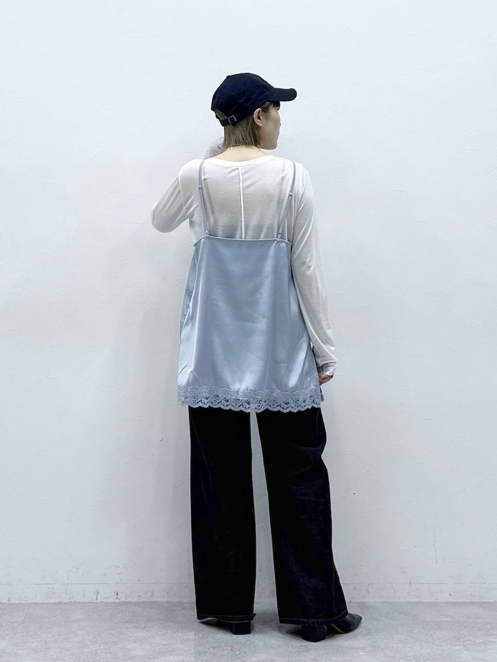 ブラック系のデニムパンツ、ブルー系のキャミソール、ホワイト系のTシャツ/カットソーを着用したレディースの冬コーディネートの6枚目の写真