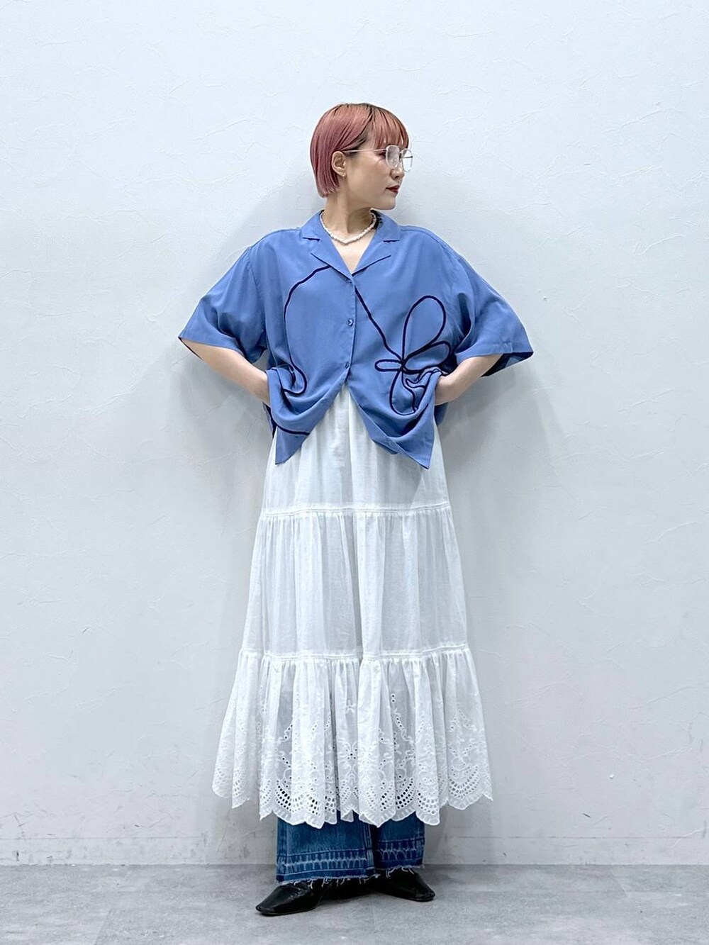 ブルー系のデニムパンツ、ブルー系のシャツ/ブラウス、ホワイト系のスカートを着用したレディースの春コーディネートの4枚目の写真