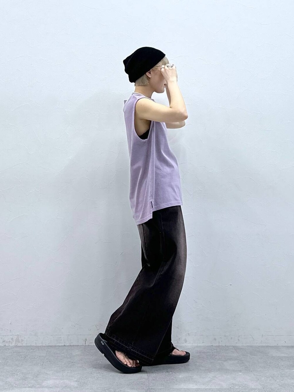 ブラック系のデニムパンツ、パープル系のTシャツ/カットソー、ブラック系のサンダルを着用したレディースの夏コーディネートの6枚目の写真