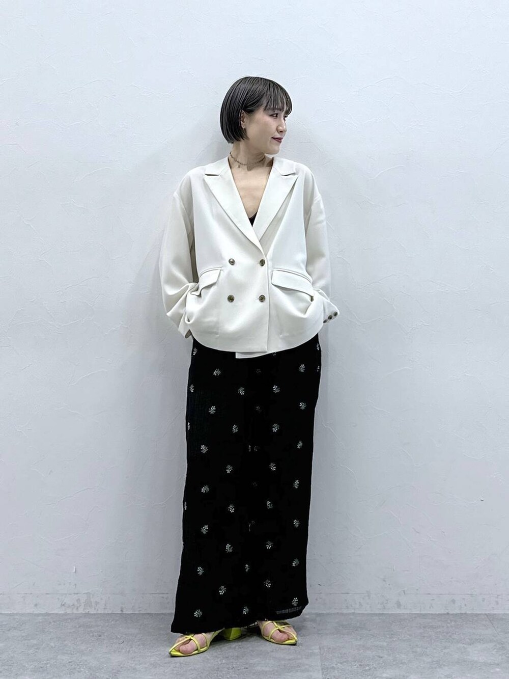 ブラック系のスラックスを着用したレディースの春コーディネートの2枚目の写真