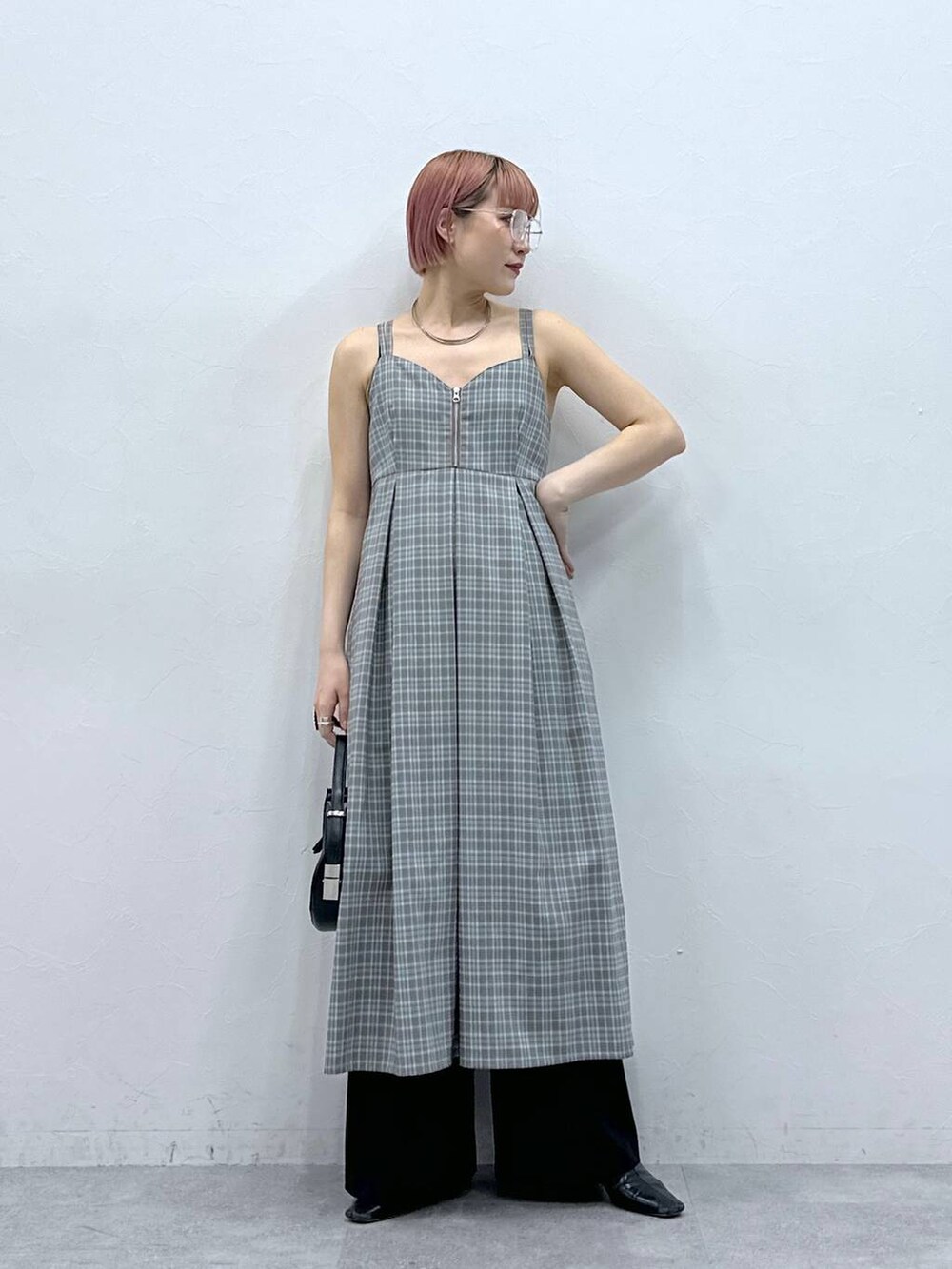 グレー系のワンピース、ブラック系のスラックスを着用したレディースの春コーディネートの3枚目の写真