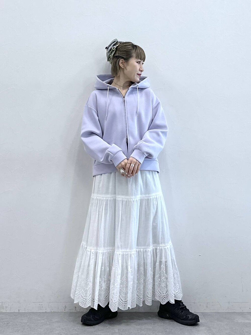 パープル系のパーカー、ホワイト系のスカートを着用したレディースの冬コーディネートの3枚目の写真