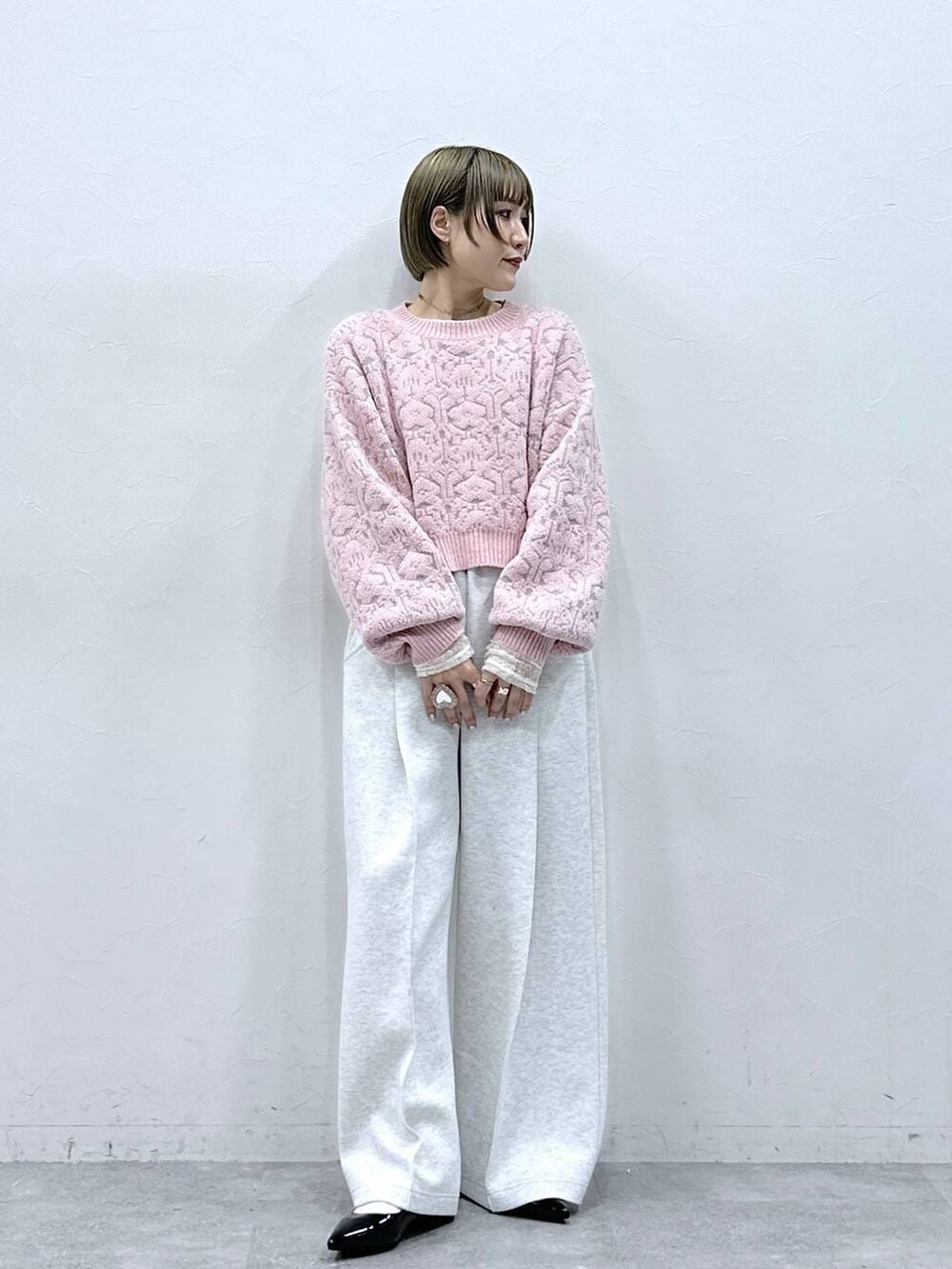 ホワイト系のTシャツ/カットソー、ブラック系のパンプス、ピンク系のニット/セーターを着用したレディースの冬コーディネートの6枚目の写真