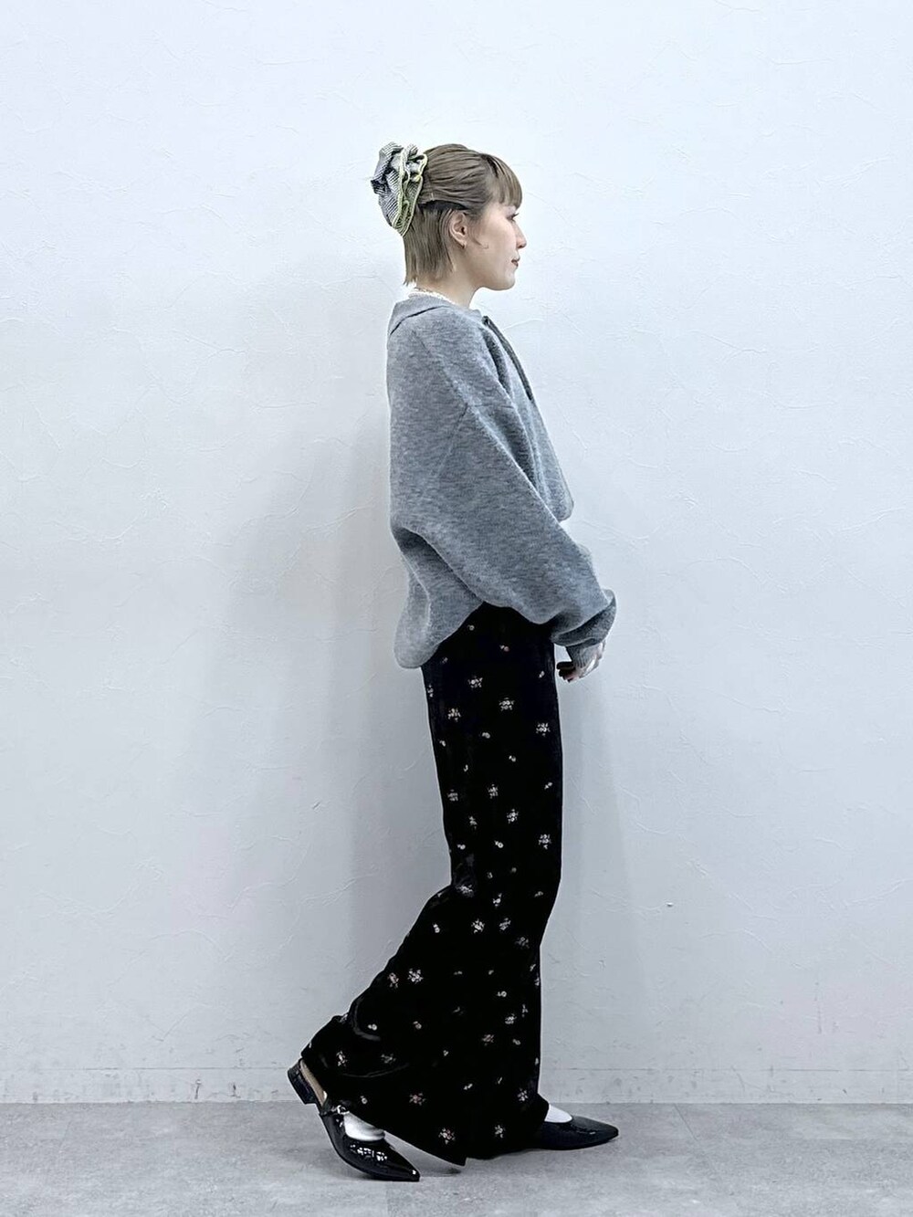 ブラック系のスウェットパンツ、グレー系のポロシャツ、ブラック系のパンプスを着用したレディースの冬コーディネートの4枚目の写真