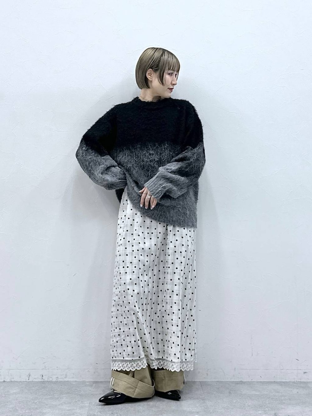 ブラック系のニット/セーター、ブラック系のパンプス、ベージュ系のチノパンツを着用したレディースの冬コーディネートの5枚目の写真