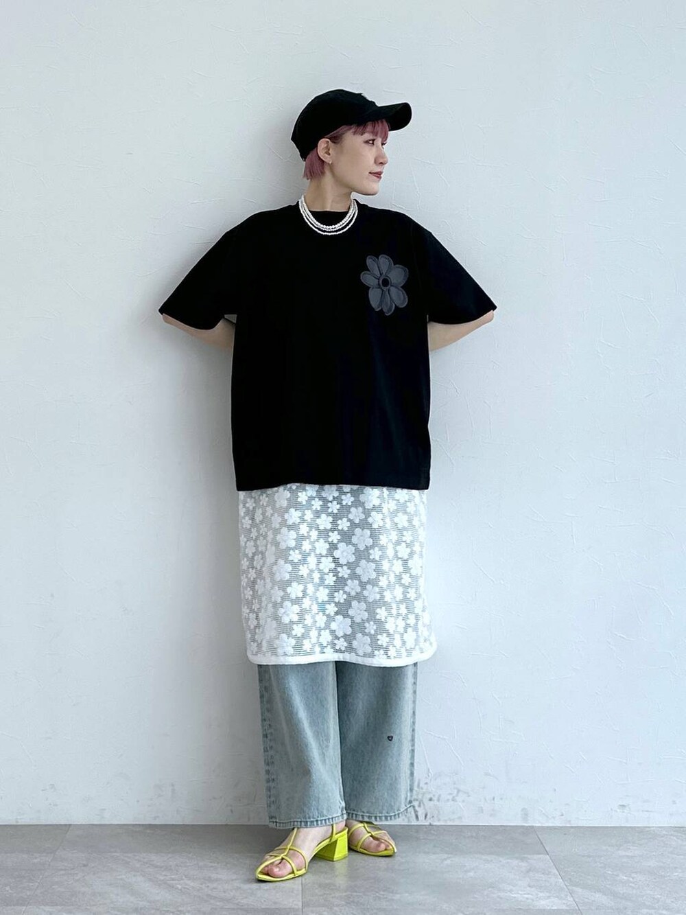ブルー系のデニムパンツ、ホワイト系のワンピース、ブラック系のTシャツ/カットソーを着用したレディースの春コーディネートの5枚目の写真