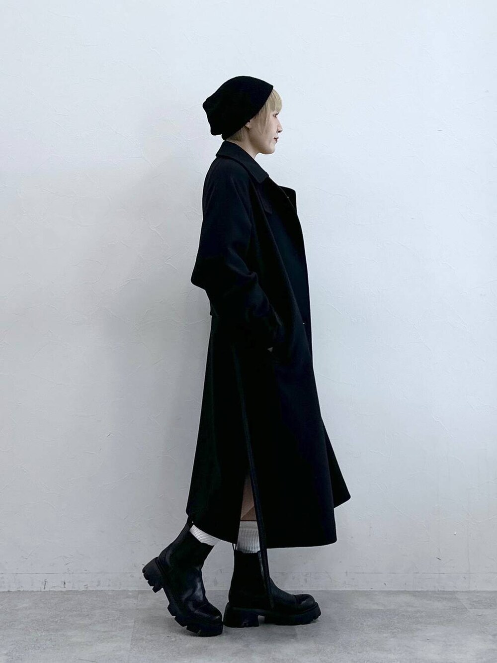 ブラック系のスラックス、イエロー系のニット/セーター、ブラック系のブーツを着用したレディースの秋コーディネートの6枚目の写真