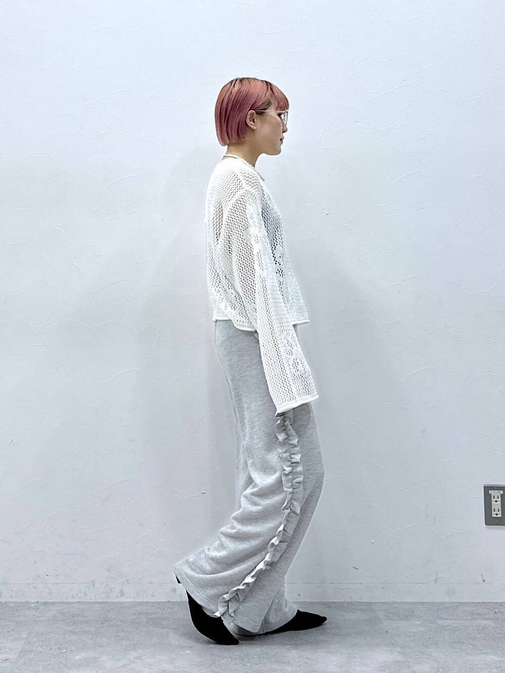 グレー系のスウェットパンツ、ホワイト系のニット/セーター、ホワイト系のネックレスを着用したレディースの春コーディネートの4枚目の写真