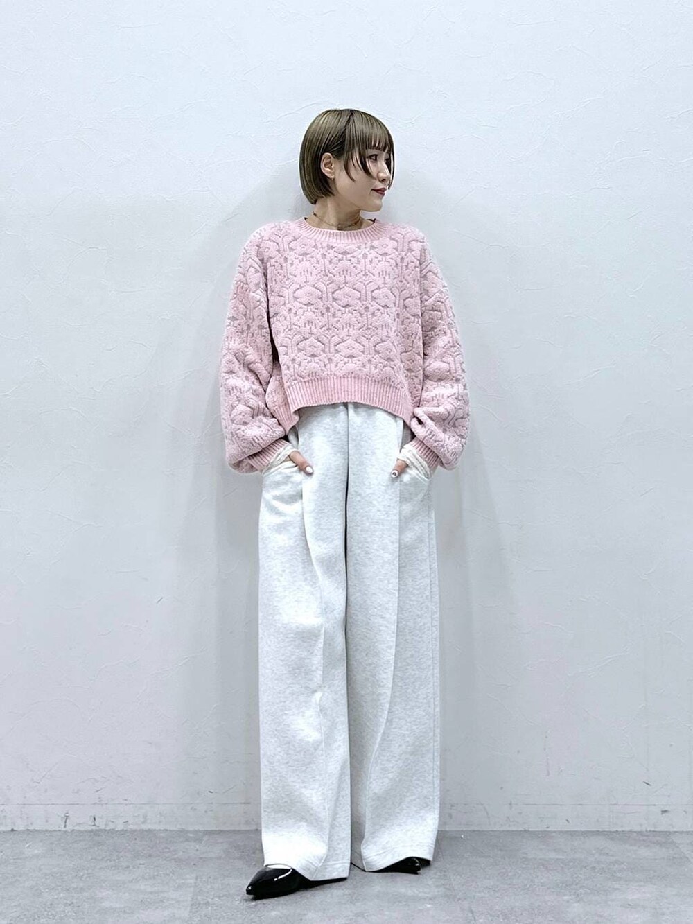ホワイト系のTシャツ/カットソー、ブラック系のパンプス、ピンク系のニット/セーターを着用したレディースの冬コーディネートの4枚目の写真
