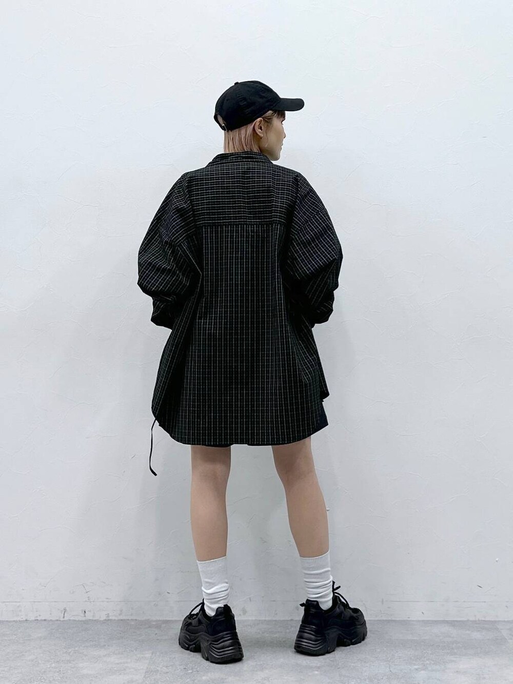 ブラック系のスニーカー、ブルー系のスラックス、ブラック系のシャツ/ブラウスを着用したレディースの春コーディネートの5枚目の写真