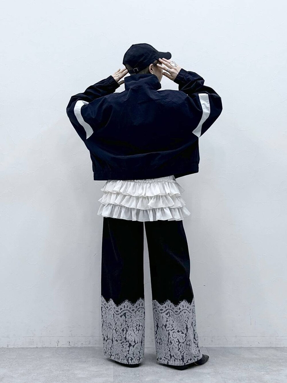 ホワイト系のキャミソール、ブルー系のブルゾン、ブラック系のデニムパンツを着用したレディースの冬コーディネートの5枚目の写真