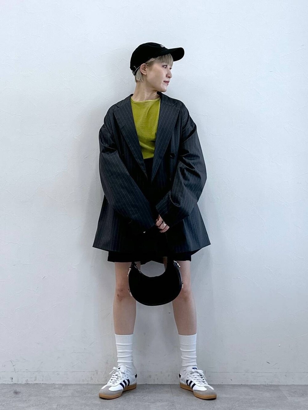 ブラック系のチノパンツ、グリーン系のTシャツ/カットソー、グレー系のテーラードジャケットを着用したレディースの冬コーディネートの2枚目の写真