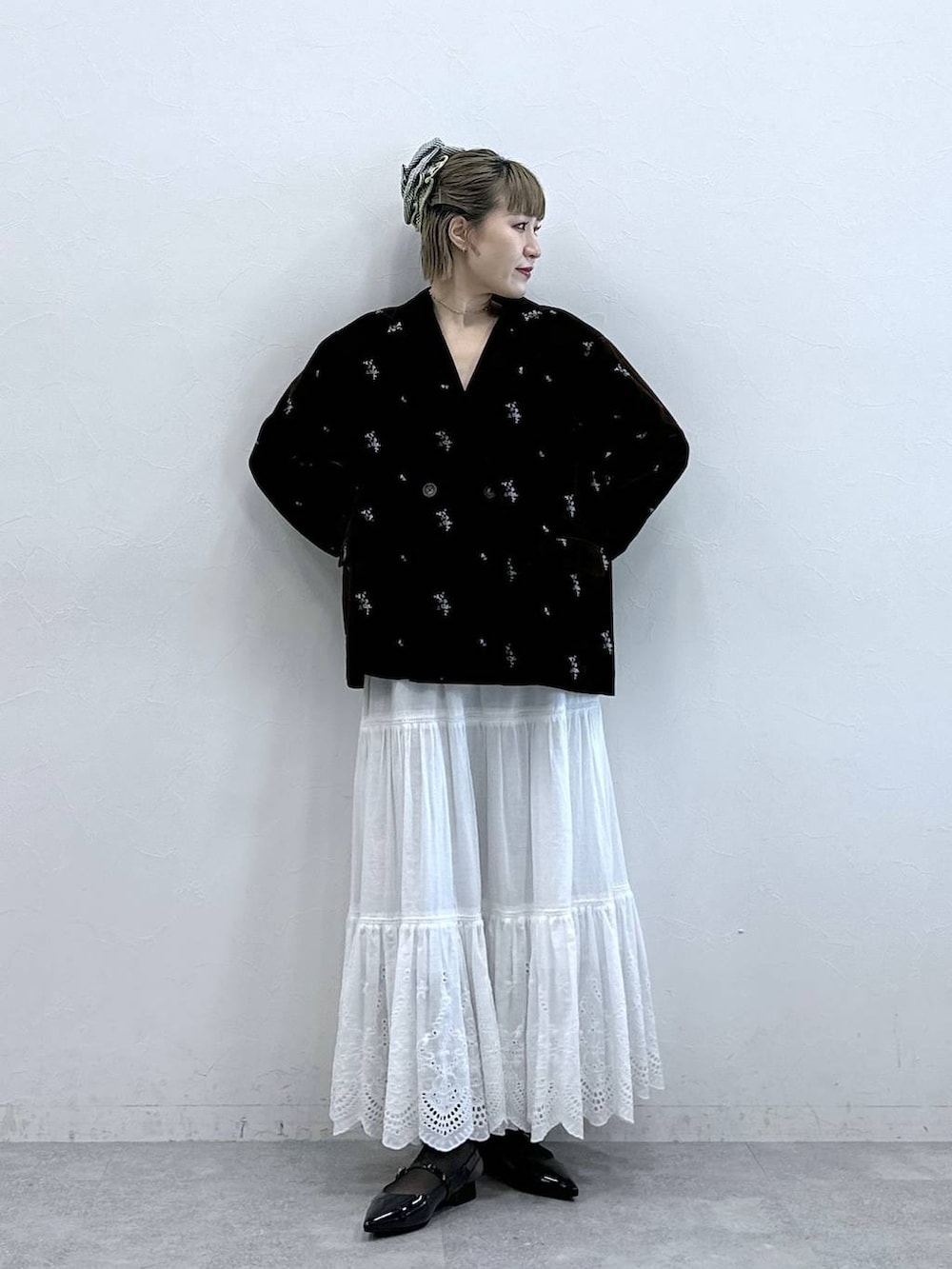 ブラック系のパンプス、ブラック系のテーラードジャケット、ホワイト系のスカートを着用したレディースの冬コーディネートの2枚目の写真