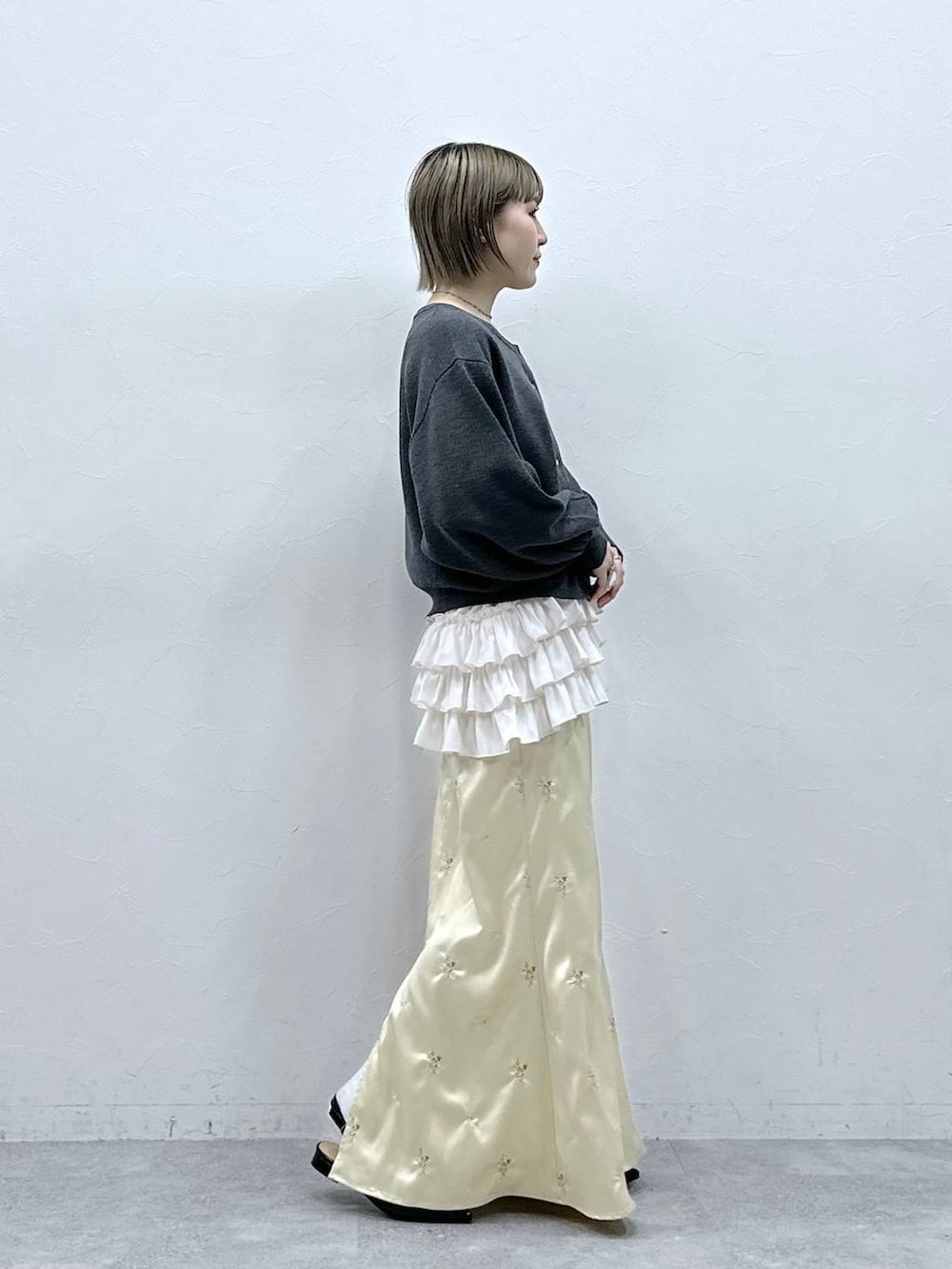 ホワイト系のキャミソール、ブラック系のパンプス、グレー系のカーディガン/ボレロを着用したレディースの冬コーディネートの4枚目の写真