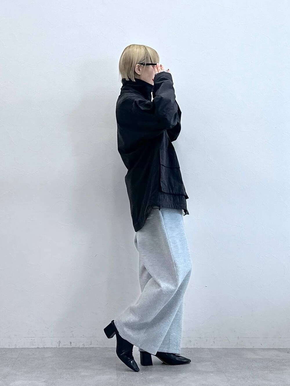 ブラック系のブルゾン、グレー系のスウェットパンツ、グレー系のメガネを着用したレディースの秋コーディネートの4枚目の写真
