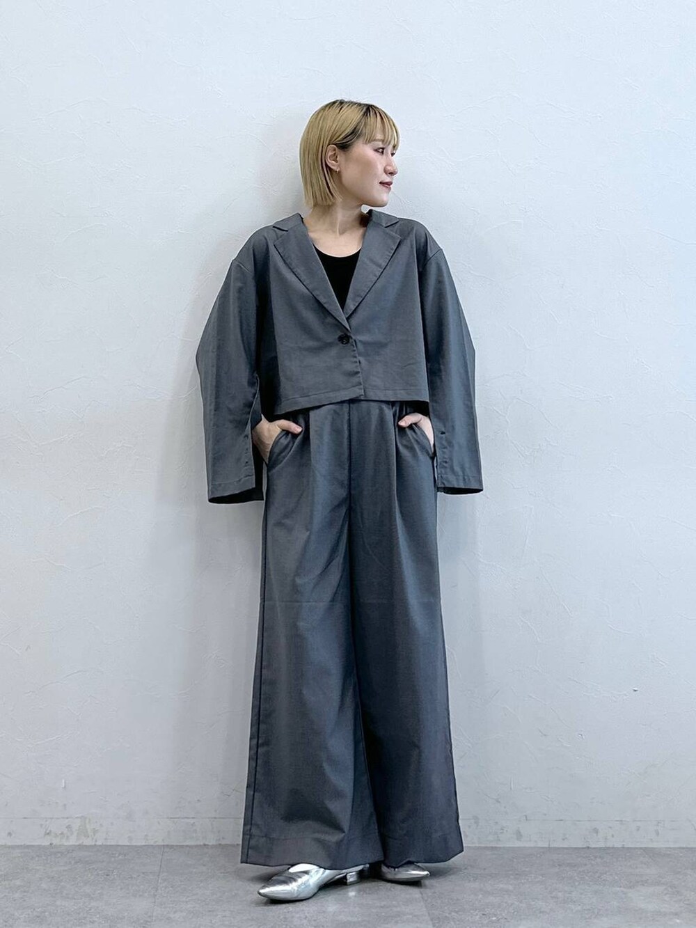 グレー系のテーラードジャケットを着用したレディースの夏コーディネートの2枚目の写真