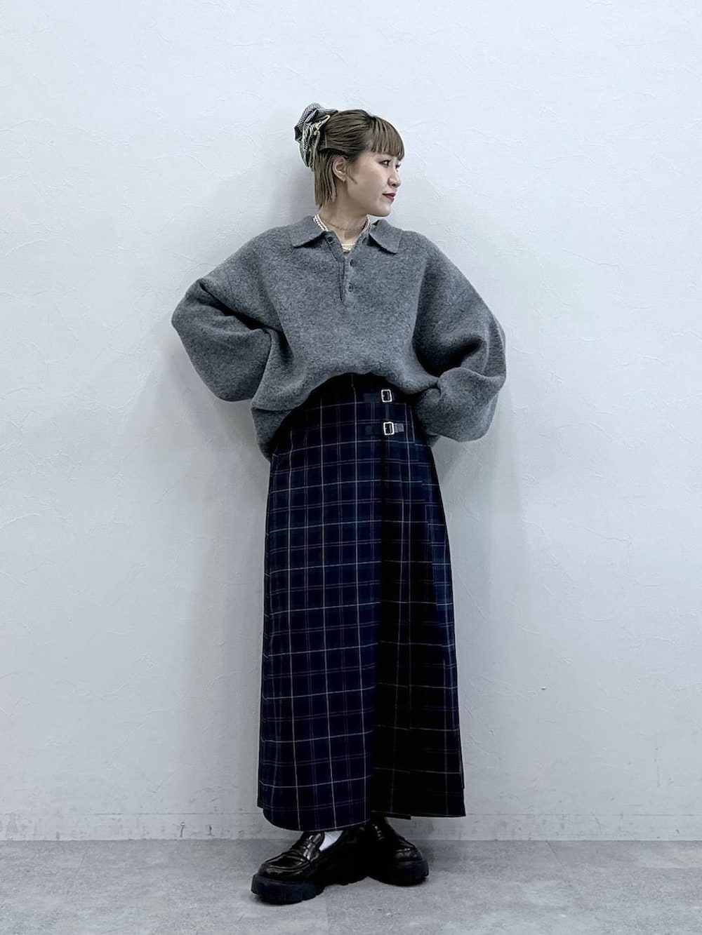 ブラック系のローファー、グリーン系のスカート、グレー系のポロシャツを着用したレディースの冬コーディネートの4枚目の写真