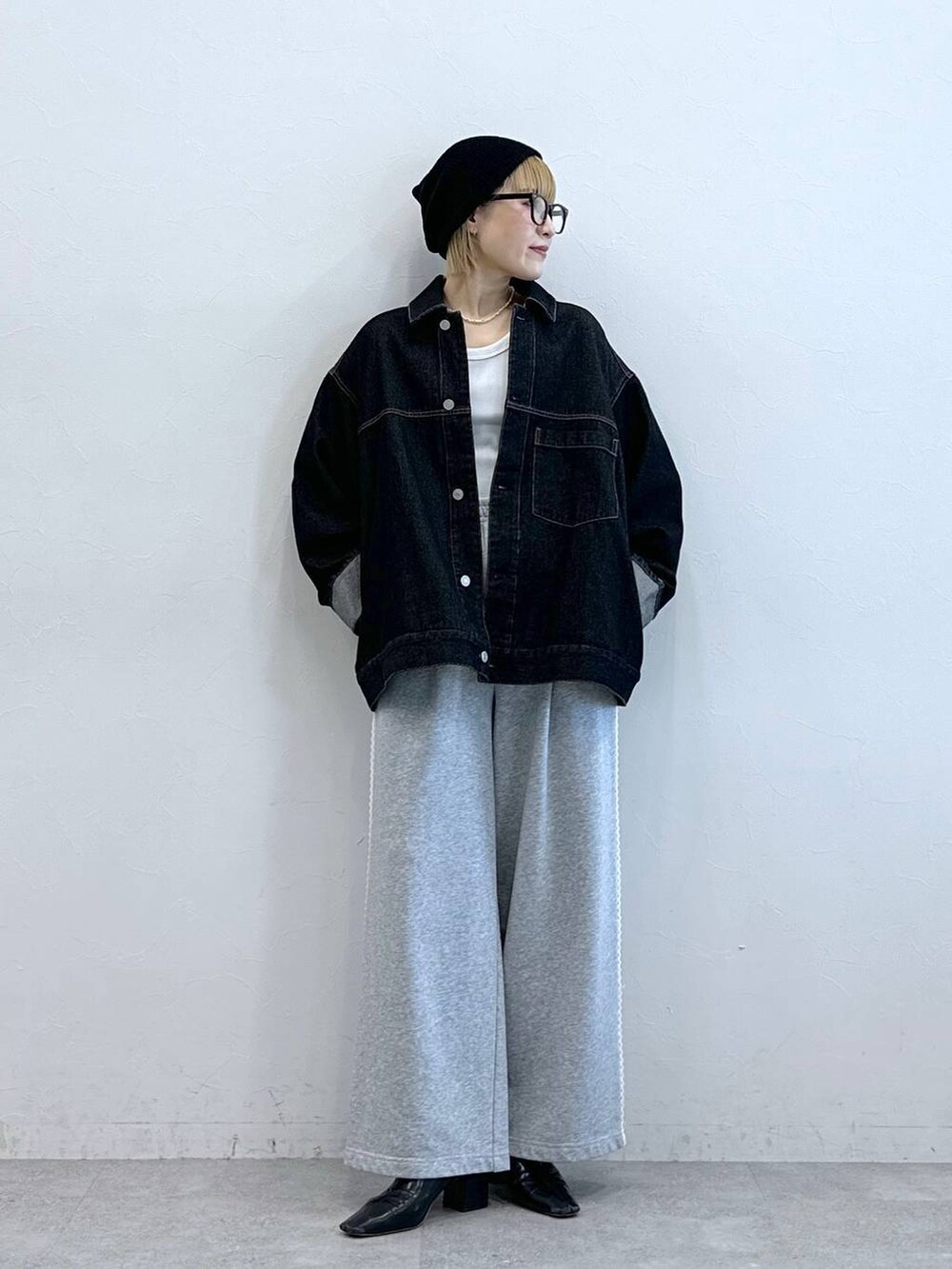 ブラック系のデニムジャケット、グレー系のスウェットパンツ、ブラック系のニットキャップ/ビーニーを着用したレディースの夏コーディネートの3枚目の写真