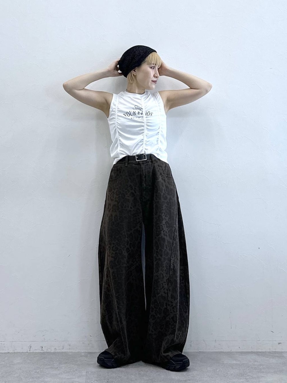 ブラック系のサンダル、ブラウン系のデニムパンツ、ホワイト系のTシャツ/カットソーを着用したレディースの春コーディネートの3枚目の写真