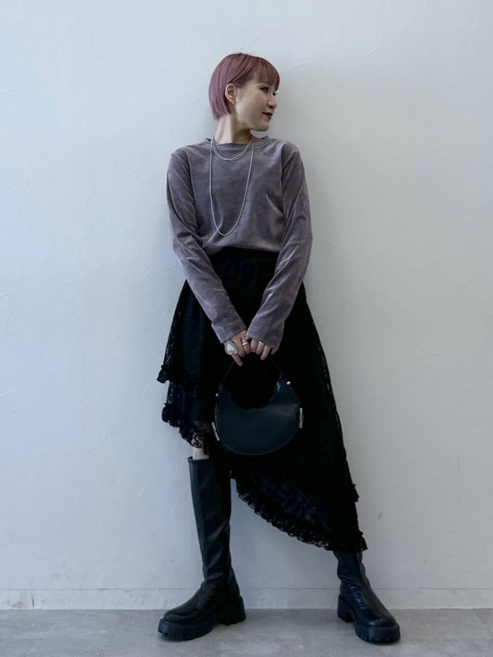 ブラック系のブーツ、パープル系のTシャツ/カットソー、ブラック系のスカートを着用したレディースの冬コーディネートの3枚目の写真
