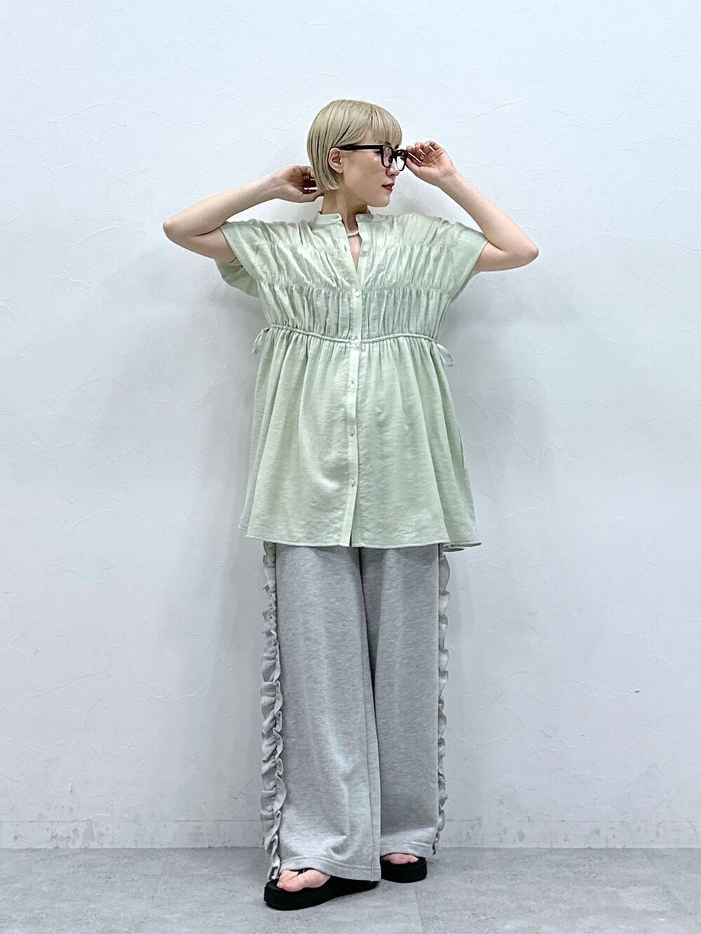 グレー系のスウェットパンツ、グリーン系のシャツ/ブラウス、ブラック系のサンダルを着用したレディースの夏コーディネートの4枚目の写真