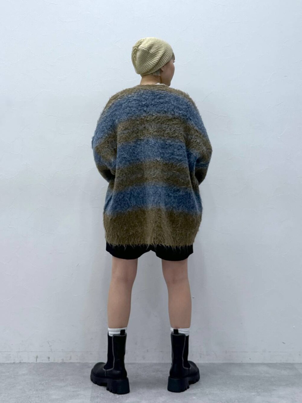 ブラック系のチノパンツ、ホワイト系のTシャツ/カットソー、ブラック系のブーツを着用したレディースの秋コーディネートの5枚目の写真