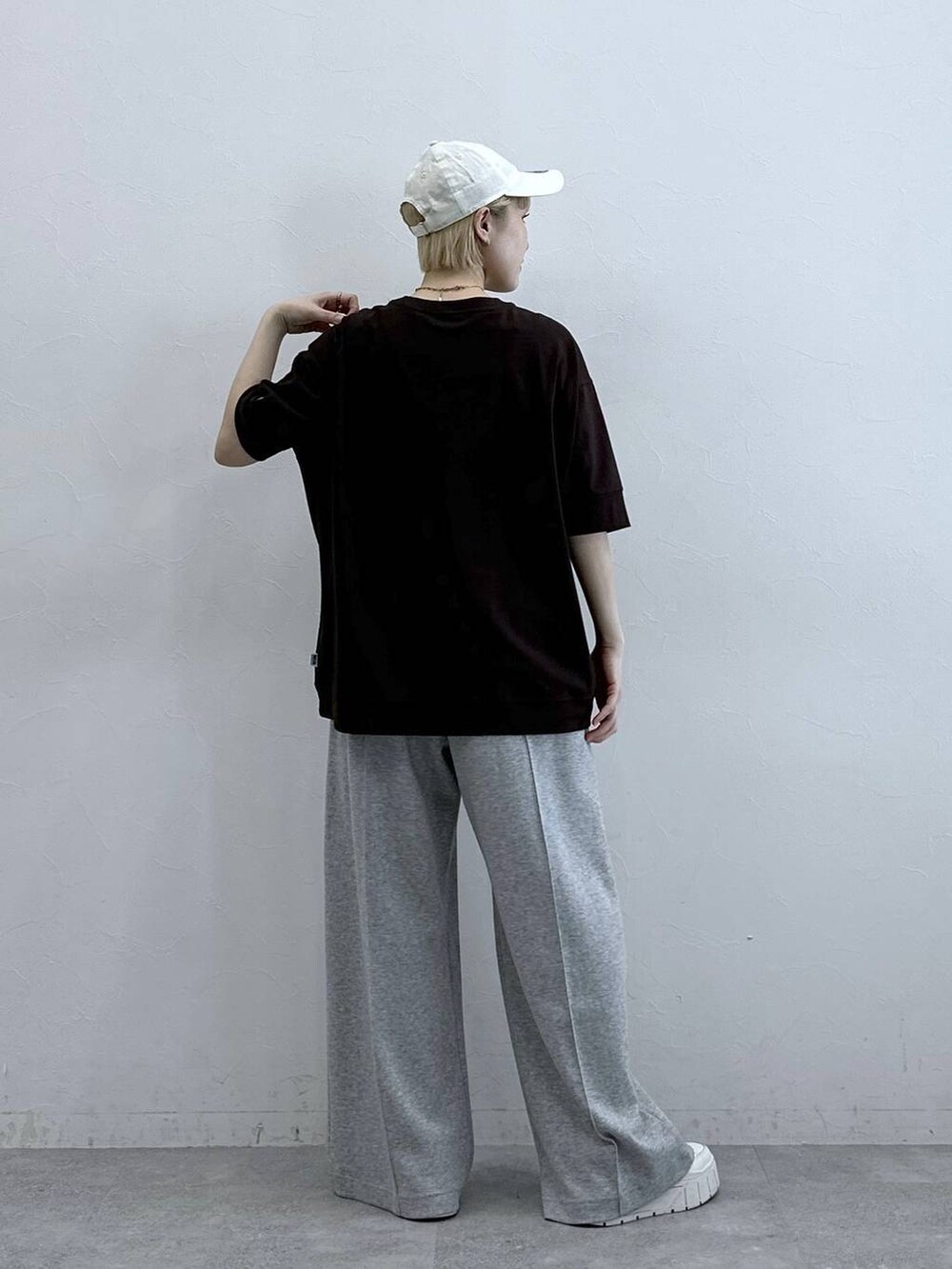 ブラウン系のTシャツ/カットソー、グレー系のスウェットパンツ、ホワイト系のキャップを着用したレディースの春コーディネートの6枚目の写真