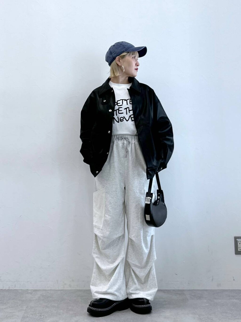 ホワイト系のカーゴパンツ、ホワイト系のTシャツ/カットソー、ブラック系のブルゾンを着用したレディースの夏コーディネートの3枚目の写真