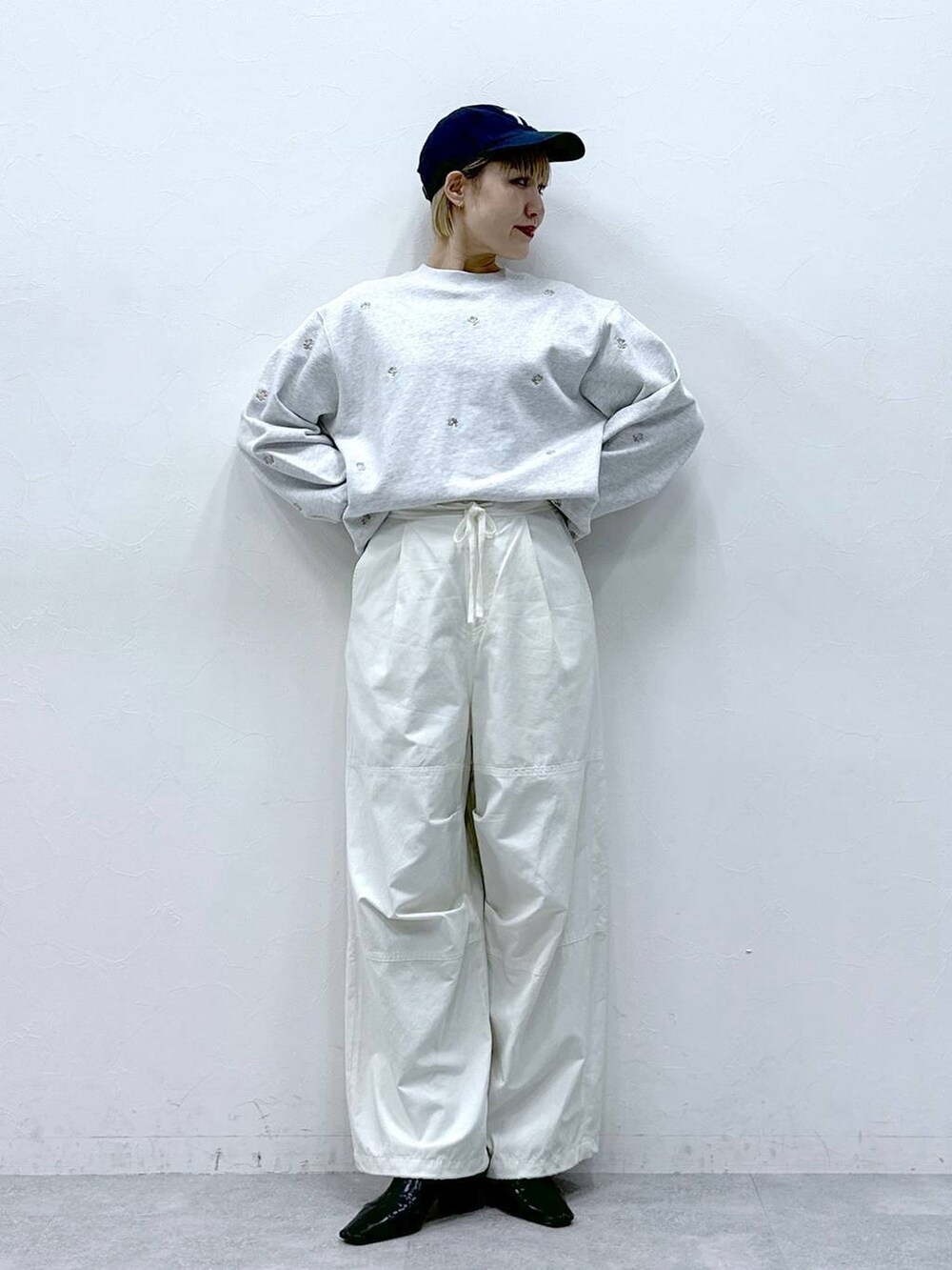 ホワイト系のカーゴパンツ、ホワイト系のスウェット、ブラック系のキャップを着用したレディースの冬コーディネートの7枚目の写真