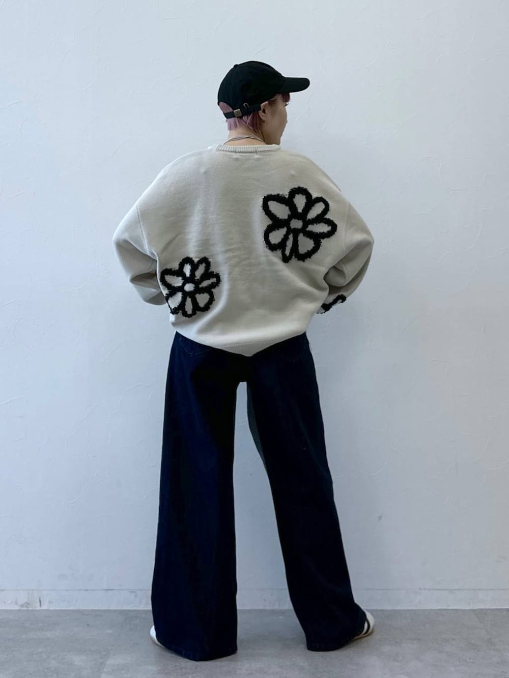 ホワイト系のニット/セーター、ブルー系のデニムパンツ、ホワイト系のスニーカーを着用したレディースの冬コーディネートの5枚目の写真