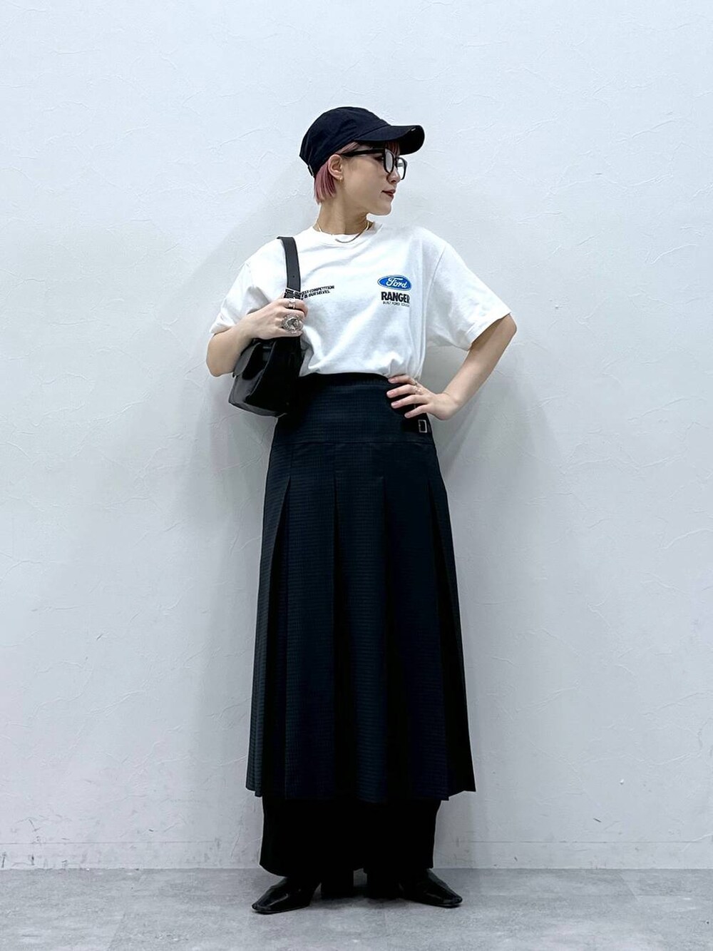 ブラック系のスラックス、グレー系のスカート、ホワイト系のTシャツ/カットソーを着用したレディースの春コーディネートの2枚目の写真