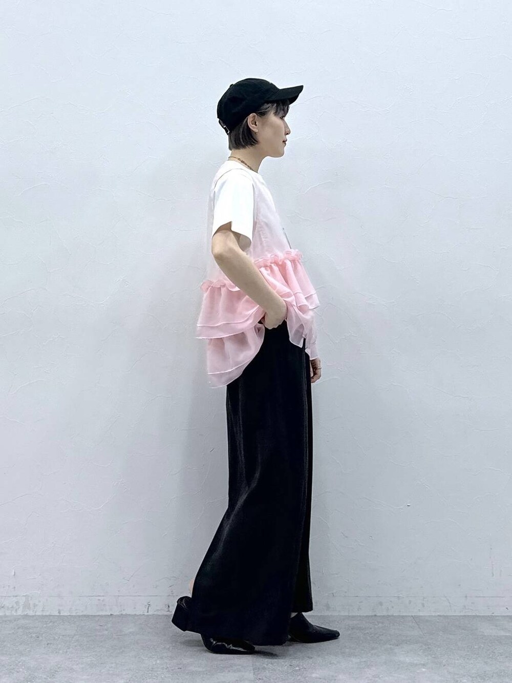 ブラック系のスカート、ホワイト系のTシャツ/カットソー、ピンク系のベストを着用したレディースの春コーディネートの4枚目の写真